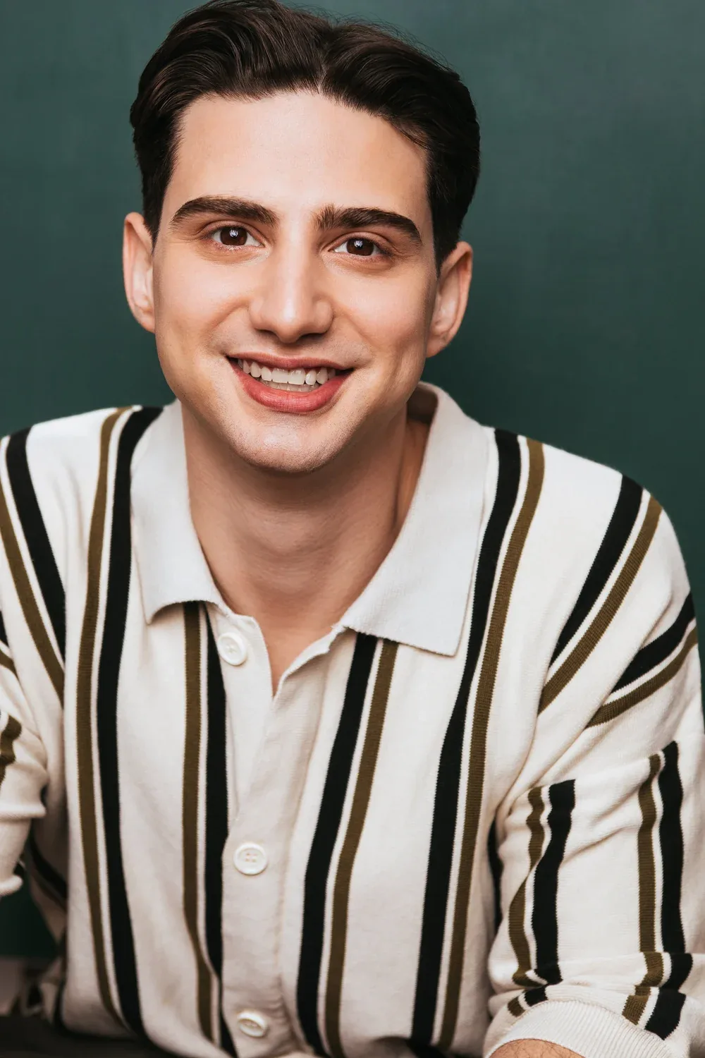 Headshot, smiling, green background